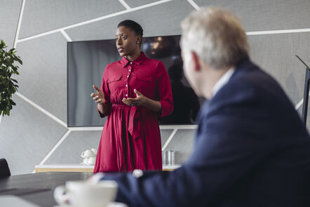 Business professional presenting to executive team