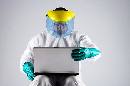 Man in a hazmat suit using a laptop