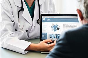 doctor showing laptop image on a person in black top ©Photo by rawpixel on Unsplash